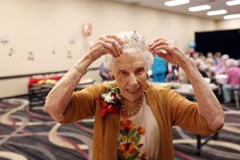 16062026 One-hundred-and-five year old Edith Edmundson laughs while trying on a tiara gifted to her by longtime friend Georgette Ashcroft during her birthday celebration at the Victoria Inn in Brandon, Manitoba on Tuesday. Edmundson turned 105 on June fourth and is celebrating her birthday four times. Festivities started last week in B.C. where Edmundson has been living with her daughter Rhonda Kremko for the last four years. Last Saturday friends and relatives raised a glass to her in Shoal Lake. Her fourth party will be this weekend in Winnipeg. (Tim Smith/The Brandon Sun)
                                Tim Smith/The Brandon Sun
                                Edith Edmundson tries on a tiara gifted to her by longtime friend Georgette Ashcroft during her 105th birthday party in Brandon.