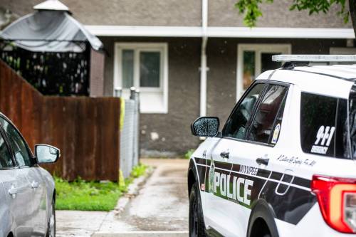 MIKAELA MACKENZIE / FREE PRESS
                                Police officers, including a forensic unit, left the townhouse at about 2 p.m. Friday.