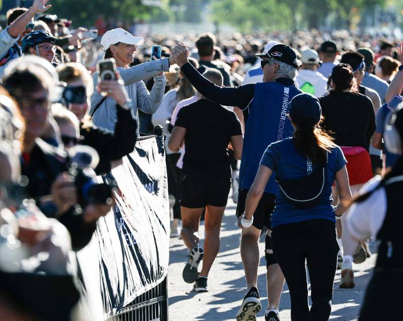 JOHN WOODS / FREE PRESS Tammy Gibson reaches out to her husband Barry as he and other runners start their 10K runs in the Manitoba Marathon at the University of Manitoba Sunday, June 21, 2026. reporter: ?