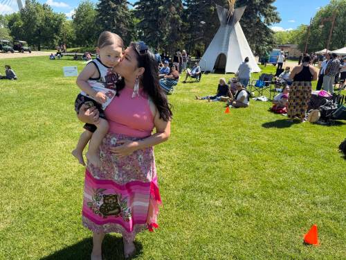 MORGAN MODJESKI / FREE PRESS
                                Diandra Ballantyne, from the Mosakahiken Cree Nation, gives her son Denzin, almost two, a smooch on Indigenous Peoples Day at the Forks in Winnipeg on June 21, 2026. She says the event is about celebrating Indigenous people, but also about the future as well.