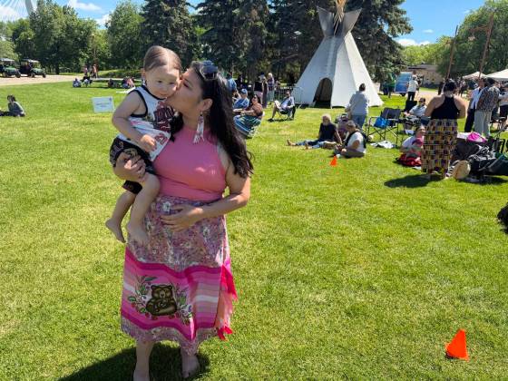 Diandra Ballantyne, from the Mosakahiken Cree Nation, gives her son Denzin, almost two, a smooch on Indigenous Peoples Day at The Forks in Winnipeg on June 21, 2026. She says the event is about celebrating Indigenous people and about the future. (Morgan Modjeski / Free Press)