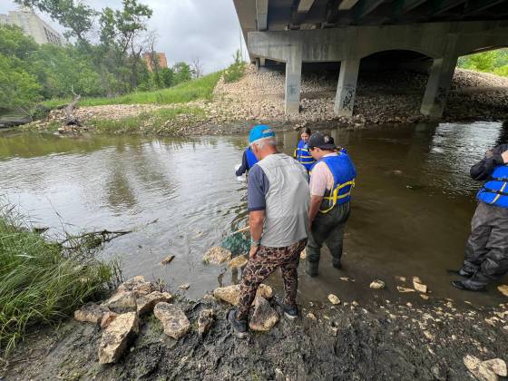 École Lacerte students collect water samples in the Seine River. (Zoe Pierce / Free Press)