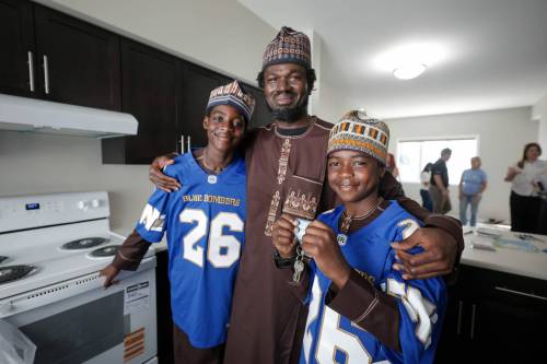RUTH BONNEVILLE / FREE PRESS
                                Suleman Gado (dad) with his sons, Mohammed (left) and Gado right, with the key to their new home through Habitat for Humanity Manitoba.