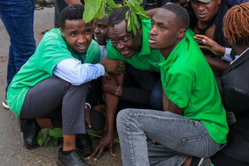 Kenya's former chief justice and presidential contender David Maraga, center, is shielded by protesters during a protest over plans affecting Nairobi National Park in Nairobi, Kenya, Monday, June 8, 2026. (AP Photo/Andrew Kasuku)