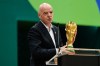 FIFA President Gianni Infantino holds the World Cup trophy as he makes comments during the opening ceremony of the International Broadcast Center, Monday, June 1, 2026, in Dallas. (AP Photo/Tony Gutierrez)