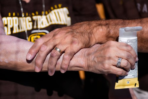 FILE - A man applies sunscreen to a woman's arm before a spring training baseball game between the San Diego Padres and the Chicago White Sox in Phoenix, Feb. 28, 2024. (AP Photo/Ashley Landis, File)