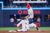 Toronto Blue Jays' Vladimir Guerrero Jr. (27) slides into Philadelphia Phillies' Bryson Stott (5) as he is out at second during third inning MLB baseball action in Toronto, on Tuesday, June 9, 2026. THE CANADIAN PRESS/Sammy Kogan