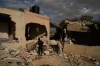 FILE -A Bedouin carries a bicycle past houses that, according to local residents, were heavily damaged yesterday during an attack by Israeli settlers in Al-Dyouk Al-Tahta area, on the outskirts of the West Bank city of Jericho, Feb. 11, 2026. (AP Photo/Leo Correa, File)