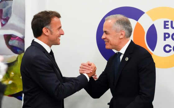 Prime Minister Mark Carney, right, shakes hands with French President Emmanuel Macron in May. (Sean Kilpatrick / The Canadian Press files)