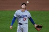 Los Angeles Dodgers two-way player Shohei Ohtani waits to hand the ball to manager Dave Roberts, after giving up a two-run double to Pittsburgh Pirates' Brandon Lowe during the seventh inning of a baseball game in Pittsburgh, Wednesday, June 10, 2026. (AP Photo/Gene J. Puskar)