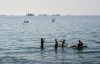 Residents swim and play in the waters of the Strait of Hormuz while cargo ships and commercial vessels lie anchored in the distance off Bandar Abbas, Iran, Wednesday, June 10, 2026.(Razieh Poudat/ISNA via AP)