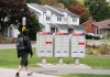 A man walks past community mailboxes in the Pointe-Claire neighbourhood of Montreal on Friday, Sept. 26, 2025. THE CANADIAN PRESS/Christinne Muschi