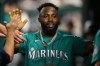 Seattle Mariners' Randy Arozarena celebrates in the dugout after he scored on a triple by Dominic Canzone during the second inning of a baseball game, Friday, June 12, 2026, in Washington. (AP Photo/Nick Wass)