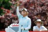 Gina Kim watches as she drops grass to check the wind before her tee shot on the 17th hole during the first round of the Dow Championship LPGA golf tournament, Thursday, June 11, 2026, at Midland Country Club in Midland, Mich. (AP Photo/Al Goldis)