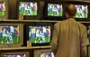 FILE - A man watches the celebrations of Senegal's soccer players during the opening match France vs. Senegal of the soccer World Championships in South Korea on a wall of TV screens in a department store in downtown Hamburg, northern Germany, May 31, 2002. (AP Photo/Kirstin Knorr, File)