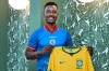 Soccer fan Peguy Joseph holds up a Brazil soccer jersey as he wears one from Haiti while posing for a photo Friday, May 22, 2026, in Ellenton, Fla. (AP Photo/Chris O'Meara)