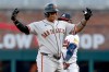 San Francisco Giants designated hitter Rafael Devers, left, reacts after hitting an RBI double as Atlanta Braves second baseman Ozzie Albies, rear, looks on during the first inning of a baseball game, Wednesday, June 17, 2026, in Atlanta. (AP Photo/Erik S. Lesser)