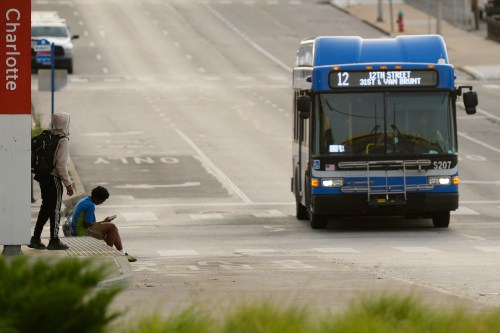 People wait for the bus at a transit center Friday, June 5, 2026, in Kansas City, Mo. (AP Photo/Charlie Riedel)