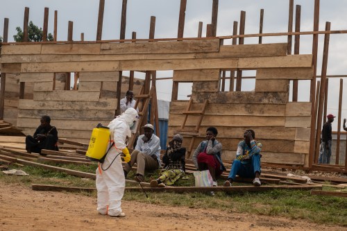 A health worker disinfects the area around a treatment center under construction at the General Hospital in Bunia, Congo, Monday, June 15, 2026. (AP Photo/Moses Sawasawa)