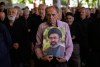 Iranian worshippers listen to the sermon of the Friday prayers as one of them holds a poster of the Supreme Leader Ayatollah Mojtaba Khamenei at the Tehran University campus in Tehran, Iran, Friday, June 19, 2026. (AP Photo/Vahid Salemi)