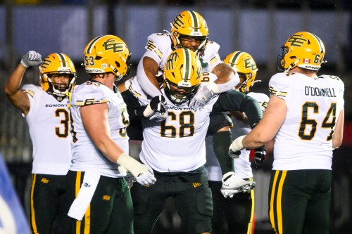 Edmonton Elks' running back Justin Rankin (5) jumps on the back of his teammate and offensive lineman Jordan Murray (68) following his touchdown against the Ottawa Redblacks during second-half CFL action in Ottawa, on Saturday, June 6, 2026. THE CANADIAN PRESS/Spencer Colby