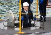 Prime Minister Mark Carney smiles as he climbs down a ladder into a submarine during a tour of the Hanwha Ocean Shipyard in Geoje Island, South Korea, on Thursday, Oct. 30, 2025. THE CANADIAN PRESS/Adrian Wyld