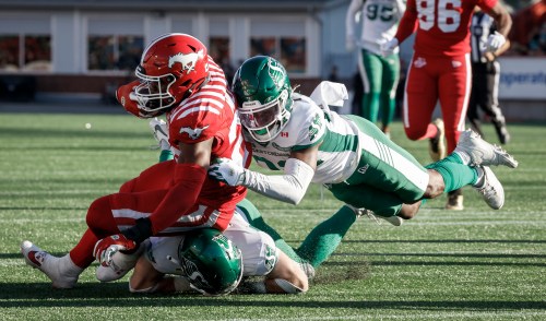 Saskatchewan Roughriders' DaMarcus Fields, right, tackles Calgary Stampeders' Dedrick Mills during second half CFL football action in Calgary, Saturday, Aug. 23, 2025.THE CANADIAN PRESS/Jeff McIntosh