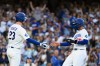 Los Angeles Dodgers' Mookie Betts, right, celebrates with Kyle Tucker, left, after scoring on a two-run single hit by Max Muncy during the first inning of a baseball game against the Baltimore Orioles in Los Angeles, Friday, June 19, 2026. (AP Photo/Kyusung Gong)