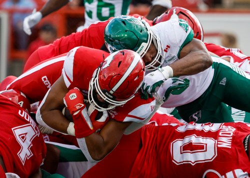 Saskatchewan Roughriders' Jameer Thurman tries to stop Calgary Stampeders quarterback Quincy Vaughn from scoring a touchdown during second half CFL action in Calgary, Saturday, June 20, 2026. THE CANADIAN PRESS/Jeff McIntosh