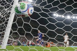 Japan's Junya Ito (14) scores their third goal past Tunisia goalkeeper Aymen Dahmen (16) during the World Cup Group F soccer match between Tunisia and Japan in Guadalupe, near Monterrey, Mexico, Saturday, June 20, 2026. (AP Photo/Dolores Ochoa)