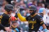 Pittsburgh Pirates' Endy Rodríguez, left, congratulates Nick Gonzales (3) who crosses home plate after hitting a two-run home run off Colorado Rockies starting pitcher Michael Lorenzen in the fourth inning of a baseball game Sunday, June 21, 2026, in Denver. (AP Photo/David Zalubowski)