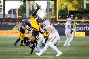 Hamilton Tiger-Cats' Kenny Lawler (89) makes a catch over B.C. Lions' T.J. Lee (back) as Ben Hladik (46) looks on during first half CFL football action in Hamilton on Friday, June 19, 2026. THE CANADIAN PRESS/Nick Iwanyshyn