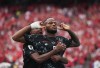 Canada's Cyle Larin (9) celebrates his goal against Qatar with Ali Ahmed (20) during the first half of a World Cup Group B soccer match, in Vancouver, on Thursday, June 18, 2026. THE CANADIAN PRESS/Darryl Dyck
