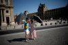 Tourists with an umbrella take a photo in Paris, as France is enduring a grueling heat wave with temperatures soaring above 40 degrees Celsius (104 Fahrenheit), Monday, June 22, 2026. (AP Photo/Christophe Ena )