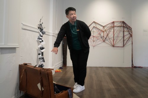 OUT Museum founder Xiangqi Chen gestures toward her art piece, 