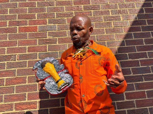 Freddy Mongkoai speaks whilst holding his artwork during an exhibition of inmates' artwork at the Leeuwkop Correctional Centre, in Johannesburg, South Africa, Monday, June 22, 2026. (AP Photo/Kayleen Morgan)