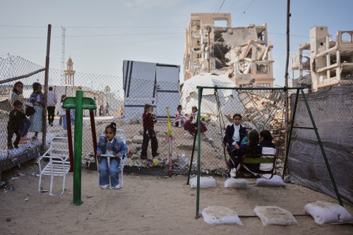 FILE - Displaced Palestinian children play on a swing at a tent camp as they mark the Muslim holiday of Eid al-Fitr in Gaza City, Friday, March 20, 2026. (AP Photo/Abdel Kareem Hana, file)