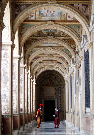 FILE - Swiss guards talk in a Vatican corridor prior to a private audience of Pope Francis to the Archbishop of Canterbury Justin Welby, at the Vatican Friday, June 14, 2013. (AP Photo/Alessandra Tarantino, file)