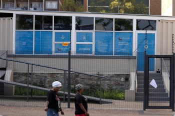 FILE - Women walk past a closed clinic run by WITS Reproductive Health Institute (RHI) as a sign on the gate reads 