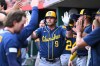 Milwaukee Brewers' Jake Bauers (9) high-fives his teammates after hitting a solo home run during the third inning of a baseball game against the Cincinnati Reds in Cincinnati, Wednesday, June 24, 2026. (AP Photo/Ben Jackson)