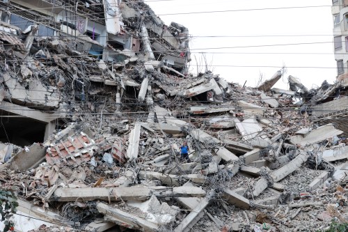 A man walks among the rubble of a building that collapsed in earthquakes the previous day in La Guaira, Venezuela, Thursday, June 25, 2026. (AP Photo/Pedro Mattey)