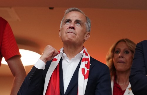 Prime Minister Mark Carney cheers as players enter the field prior to the first half of a World Cup Group B soccer match between Canada and Switzerland, in Vancouver, on Wednesday, June 24, 2026. THE CANADIAN PRESS/Ethan Cairns