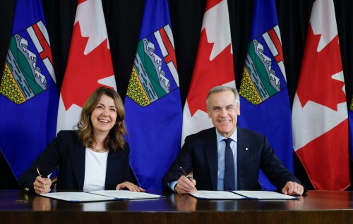 Prime Minister Mark Carney, right, signs an MOU with Alberta Premier Danielle Smith in Calgary, Alta., Thursday, Nov. 27, 2025. THE CANADIAN PRESS/Jeff McIntosh