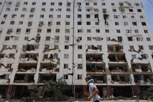 A resident walks past a damaged building a day after an earthquake and several aftershocks struck La Guaira, Venezuela, Thursday, June 25, 2026. (AP Photo/Pedro Mattey)