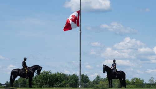 The flag flies at half mast, in honour of police officers killed recently, as members of the RCMP Musical Ride practice at the stables in Ottawa on Wednesday, June 24, 2026. THE CANADIAN PRESS/Adrian Wyld