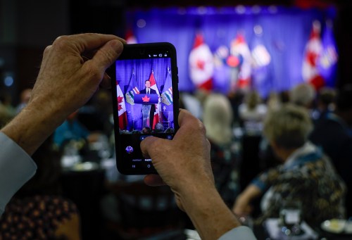 A person uses a smartphone to photograph Conservative leader Pierre Poilievre as he delivers a speech on national unity in Calgary, Monday, June 8, 2026. THE CANADIAN PRESS/Jeff McIntosh