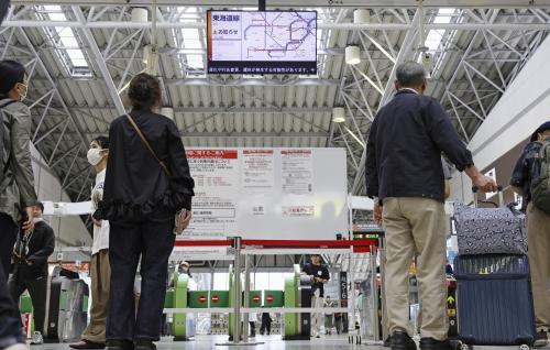 Passengers check train service status as two approaching tropical storms trigger heavy rainfalls, at JR Odawara station in Odawara, Kanagawa Prefecture, Saturday, June 27, 2026. (Kyodo News via AP)