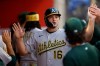 Athletics' Nick Kurtz (16) is greeted by teammates after scoring on a single by Shea Langeliers (23) during the fifth inning of a baseball game against the Los Angeles Angels, Friday, June 26, 2026, in Anaheim, Calif. (AP Photo/Caroline Brehman)