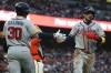 Atlanta Braves' Mauricio Dubón, right, is congratulated by Drake Baldwin (30) after scoring on a single by Ozzie Albies during the third inning of a baseball game against the San Francisco Giants in San Francisco, Friday, June 26, 2026. (AP Photo/Jed Jacobsohn)