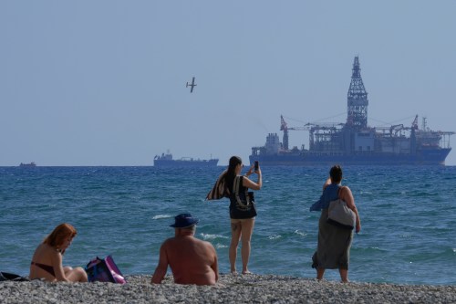 FILE - People on the beach take photos of the 'Tungsten Explored' drilling ship, in the southern coastal city of Larnaca, Cyprus, on Nov. 3, 2021. (AP Photo/Petros Karadjias, File)